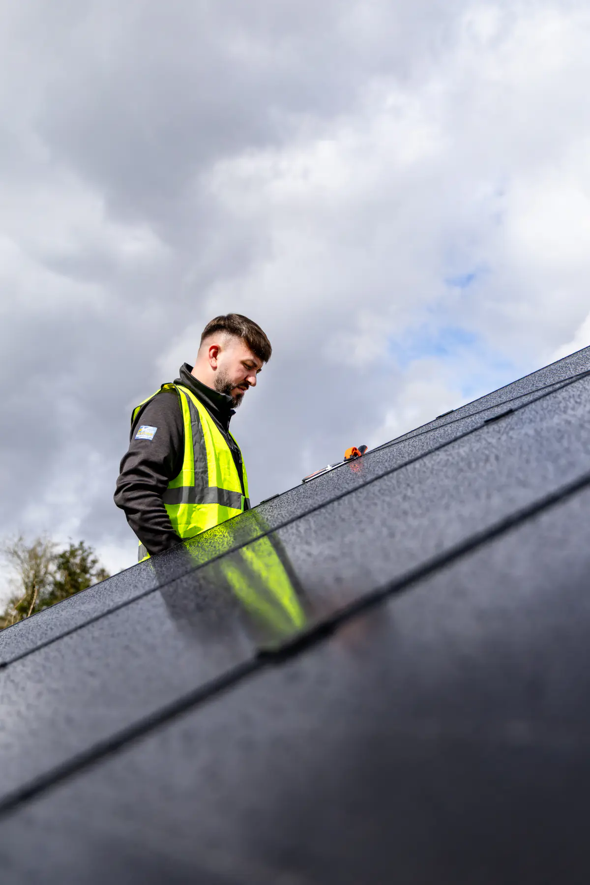 021 Electrician team member checking a ground-mounted solar panel during outdoor solar work.