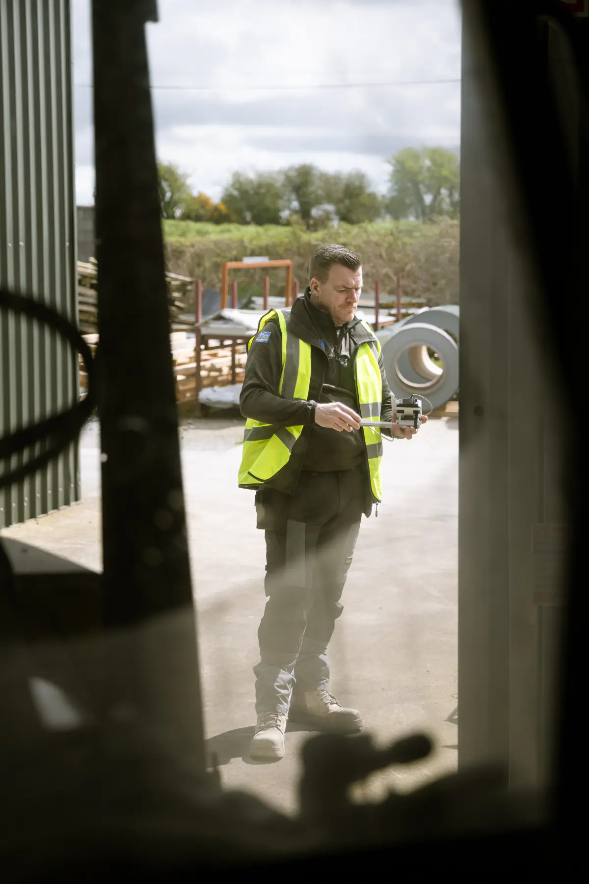 021 Electrician team member carrying electrical testing equipment at a commercial site in Cork.