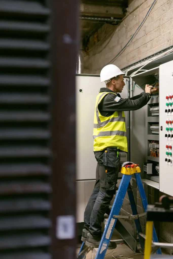 Electrician working on an open commercial electrical control panel in Cork.