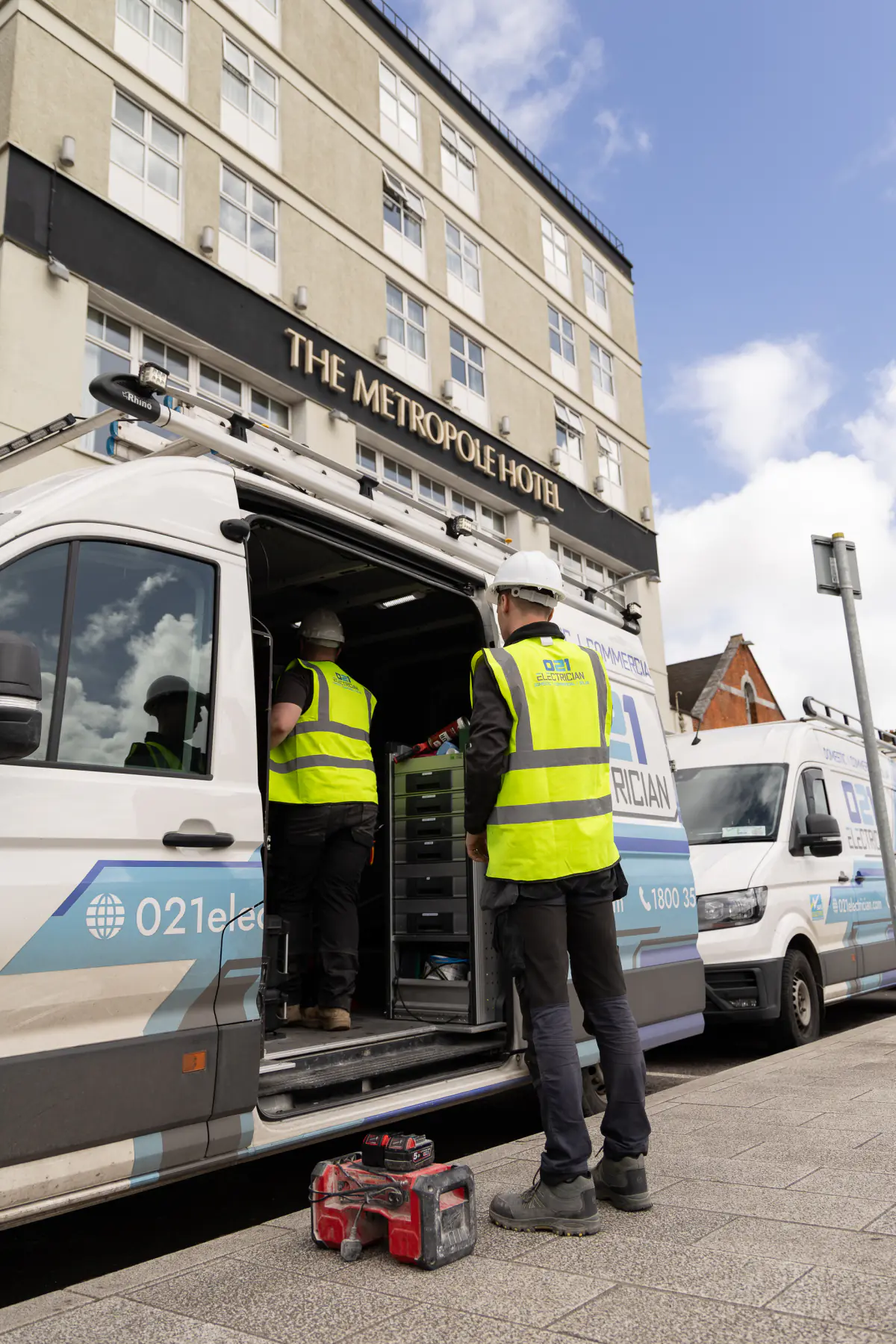 021 Electrician team preparing tools from a service van outside The Metropole Hotel Cork.